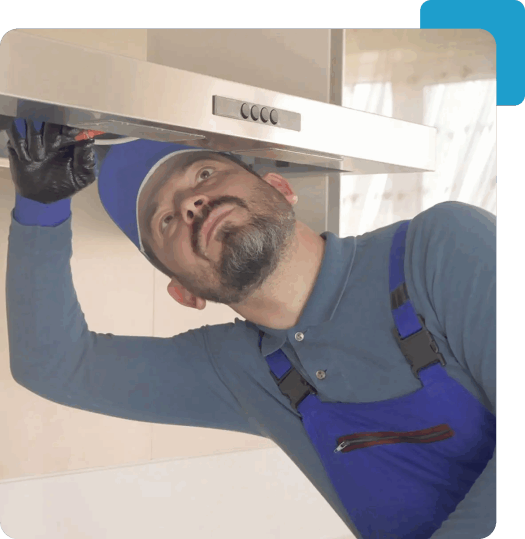 Worker inspecting a kitchen range hood.